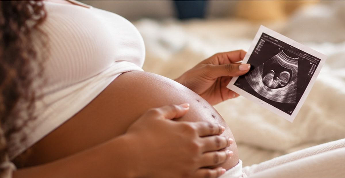 Gestante segura uma imagem de ultrassom apoiada na barriga